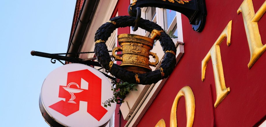 Ein Apothekenschild an einem roten Gebäude