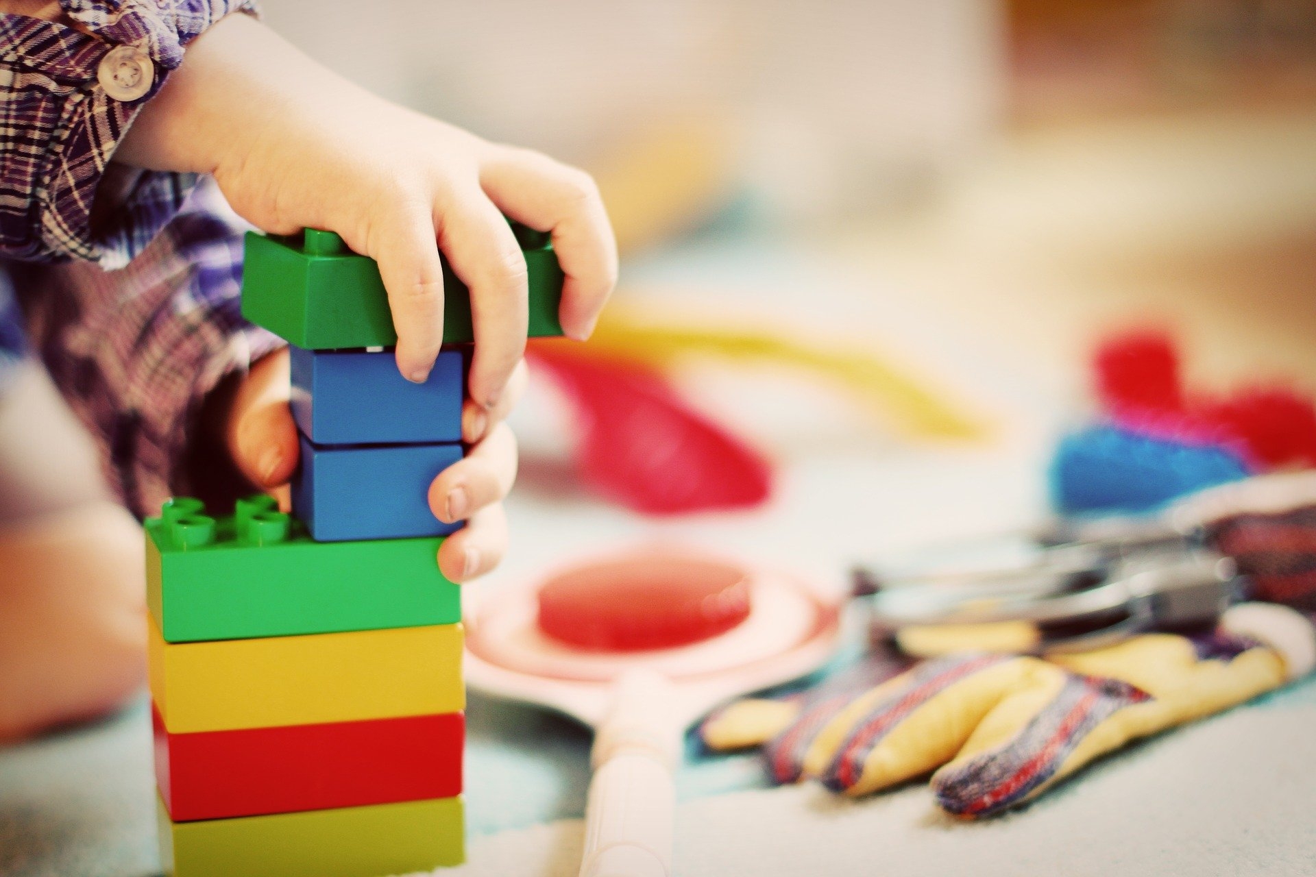 Kinderhände, die Bausteine auf einander stapeln 